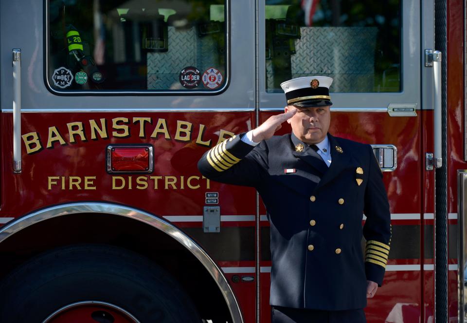 Barnstable Fire Chief Francis Pulsifer stands at attention on Sept. 11, 2021, during the singing of the National Anthem by Alayna Rooney and Dulce Romilus. The 13th annual ceremony and service of remembrance was held by the fire department and St. Mary's Episcopal Church, on the 20th anniversary of the 9/11 terrorist attacks.