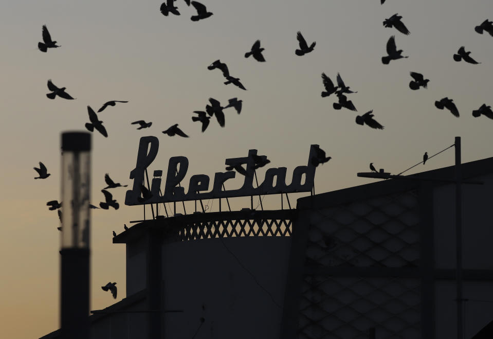 Birds fly next to a sign with the name of the Libertad Theater in San Salvador, El Salvador, Tuesday, Feb. 28, 2023. (AP Photo/Salvador Melendez)