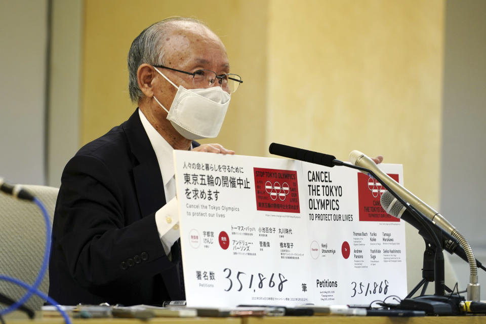 Lawyer Kenji Utsunomiya, a representative of an anti-Olympics group, holds boards showing the current figure of online petition during a press conference after submitting a petition to the Tokyo government calling for the cancellation of the Tokyo 2020 Olympics and Paralympics. An online petition calling for the Tokyo Olympics to be cancelled has been submitted to the Tokyo government with over 350,000 signatures on Friday morning. The rollout of the petition comes with Tokyo, Osaka and several other areas under a state of emergency with coronavirus infections rising - particularly new variants. (AP Photo/Eugene Hoshiko)