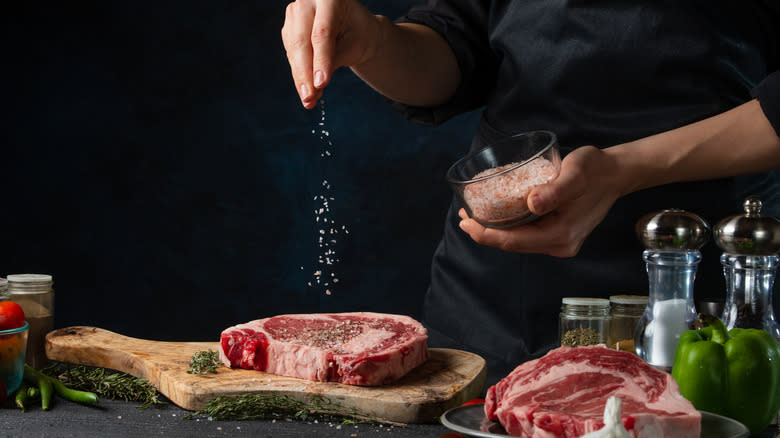 Chef salting a steak