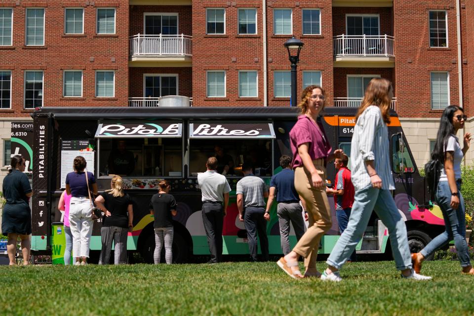 Diners order lunch from Pitabillies, one of the various options offered in the food truck food court at the Columbus Commons.