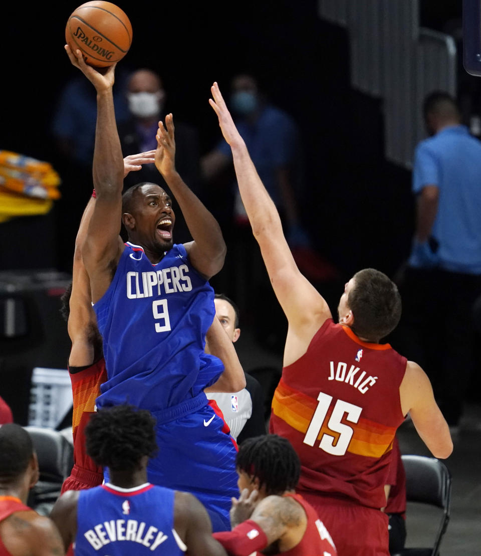 Los Angeles Clippers forward Serge Ibaka shoots over Denver Nuggets center Nikola Jokic during the first half of an NBA basketball game Friday, Dec. 25, 2020, in Denver. (AP Photo/David Zalubowski)