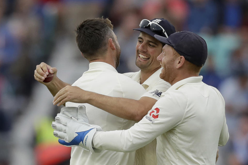 England's Jimmy Anderson, left, celebrates taking the wicket of India's Ajinkya Rahane that was caught out by England's Alastair Cook, center, during the fifth cricket test match of a five match series between England and India at the Oval cricket ground in London, Saturday, Sept. 8, 2018. (AP Photo/Matt Dunham)