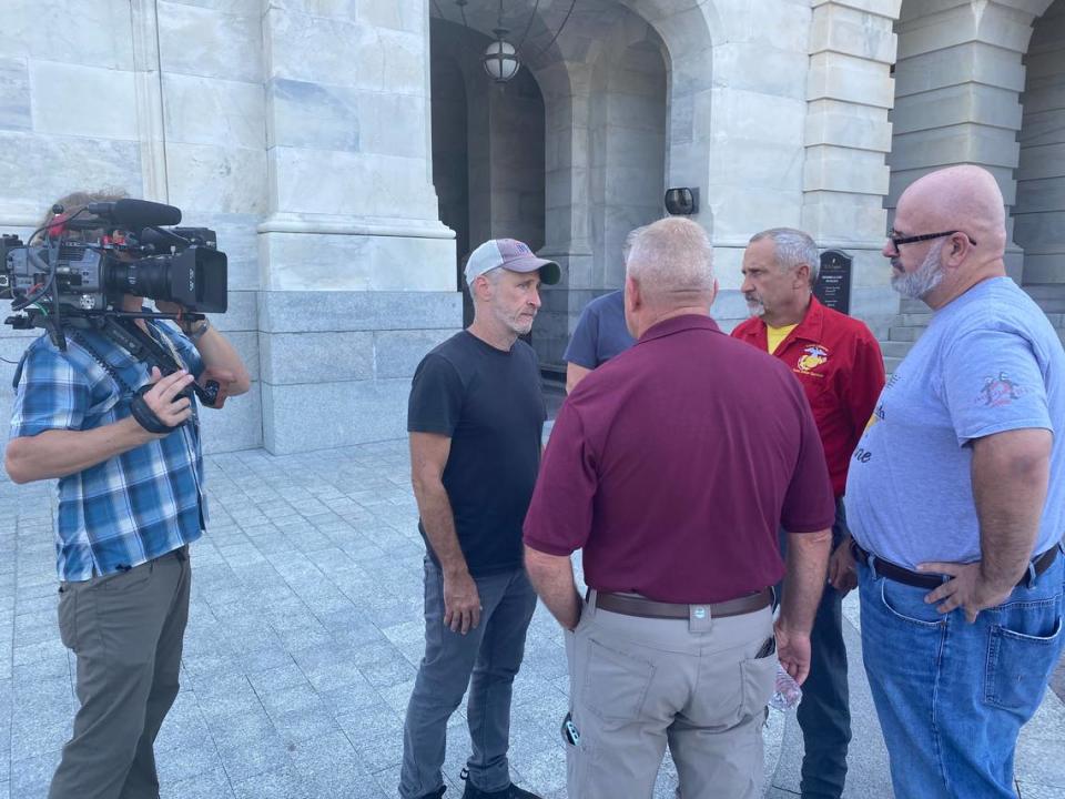 Comedian Jon Stewart stands outside the U.S. Capitol talking with Jerry Ensminger, Mike Partain and Brian Amburgey about their fight for marines stationed at Camp Lejeune.