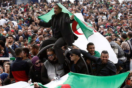 A man carries a national flag during a protest against the appointment of interim president, Abdelkader Bensalah demanding radical changes to the political system in Algiers, Algeria April 10, 2019. REUTERS/Ramzi Boudina