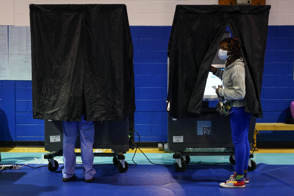 FILE - A voter looks from a booth while casting their ballot on election day in Philadelphia, Tuesday, Nov. 7, 2023. On Friday, Nov. 10, The Associated Press reported on stories circulating online incorrectly claiming Democrats cheated in Pennsylvania elections with voting machines that were rigged to flip votes. (AP Photo/Matt Rourke, File)