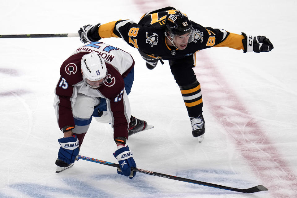 Pittsburgh Penguins' Sidney Crosby (87) collides with Colorado Avalanche's Valeri Nichushkin (13) during the first period of an NHL hockey game in Pittsburgh, Thursday, Oct. 26, 2023. (AP Photo/Gene J. Puskar)