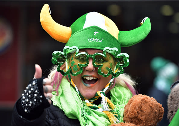 Person wearing a Viking hat and shamrock glasses celebrating St. Patrick's Day with festive attire