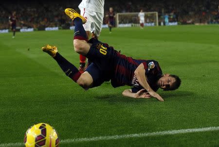 Barcelona's Lionel Messi falls after fightubg for the ball against Sevilla's Daniel Carrico during their Spanish first division soccer match at Camp Nou stadium in Barcelona November 22, 2014. REUTERS/Albert Gea