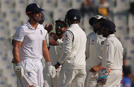 Cricket - India v England - Third Test cricket match - Punjab Cricket Association Stadium, Mohali, India - 26/11/16. Indian players celebrate the dismissal of England's Alastair Cook (L). REUTERS/Adnan Abidi