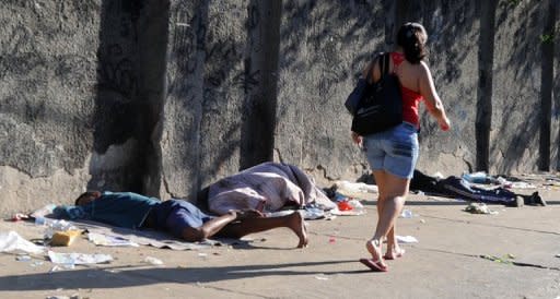 Una mujer pasa junto a unos adictos al 'crack' cerca de la favela de Jacaré, en Rio de Janeiro, en julio pasado.