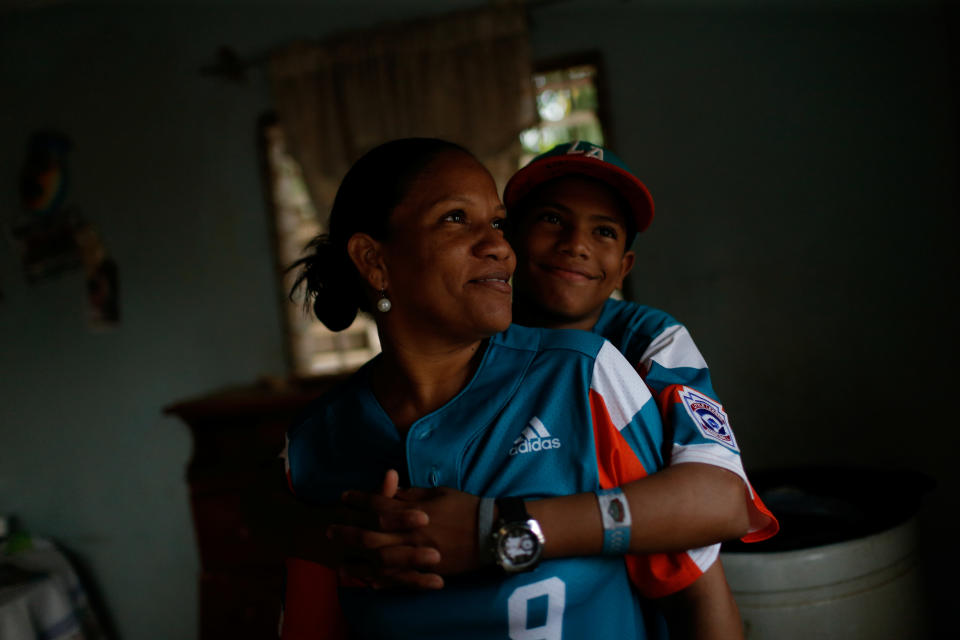 Diana Nunez, 44, mother of baseball little league player Adrian Salcedo, 13, poses for a photograph with her son at their house in Maracaibo, Venezuela. (Photo: Manaure Quintero/Reuters)