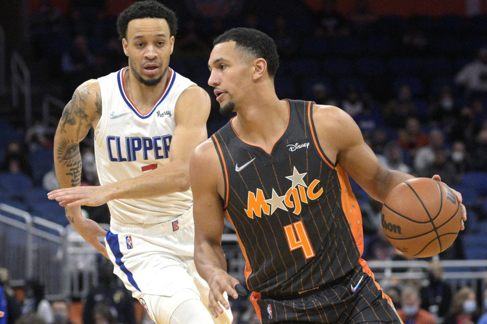 Orlando Magic guard Jalen Suggs (4) drives past Los Angeles Clippers guard Amir Coffey, left, during the first half of an NBA basketball game, Wednesday, Jan. 26, 2022, in Orlando, Fla. (AP Photo/Phelan M. Ebenhack)