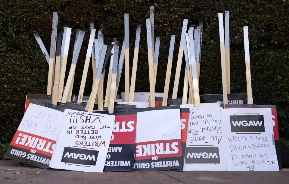 FILE - Placards are gathered together at the close of a picket by members of The Writers Guild of America outside Walt Disney Studios, Tuesday, May 2, 2023, in Burbank, Calif. On Sunday, Sept. 24, 2023, a tentative deal was reached to end Hollywood’s writers strike after nearly five months. (AP Photo/Chris Pizzello, File)