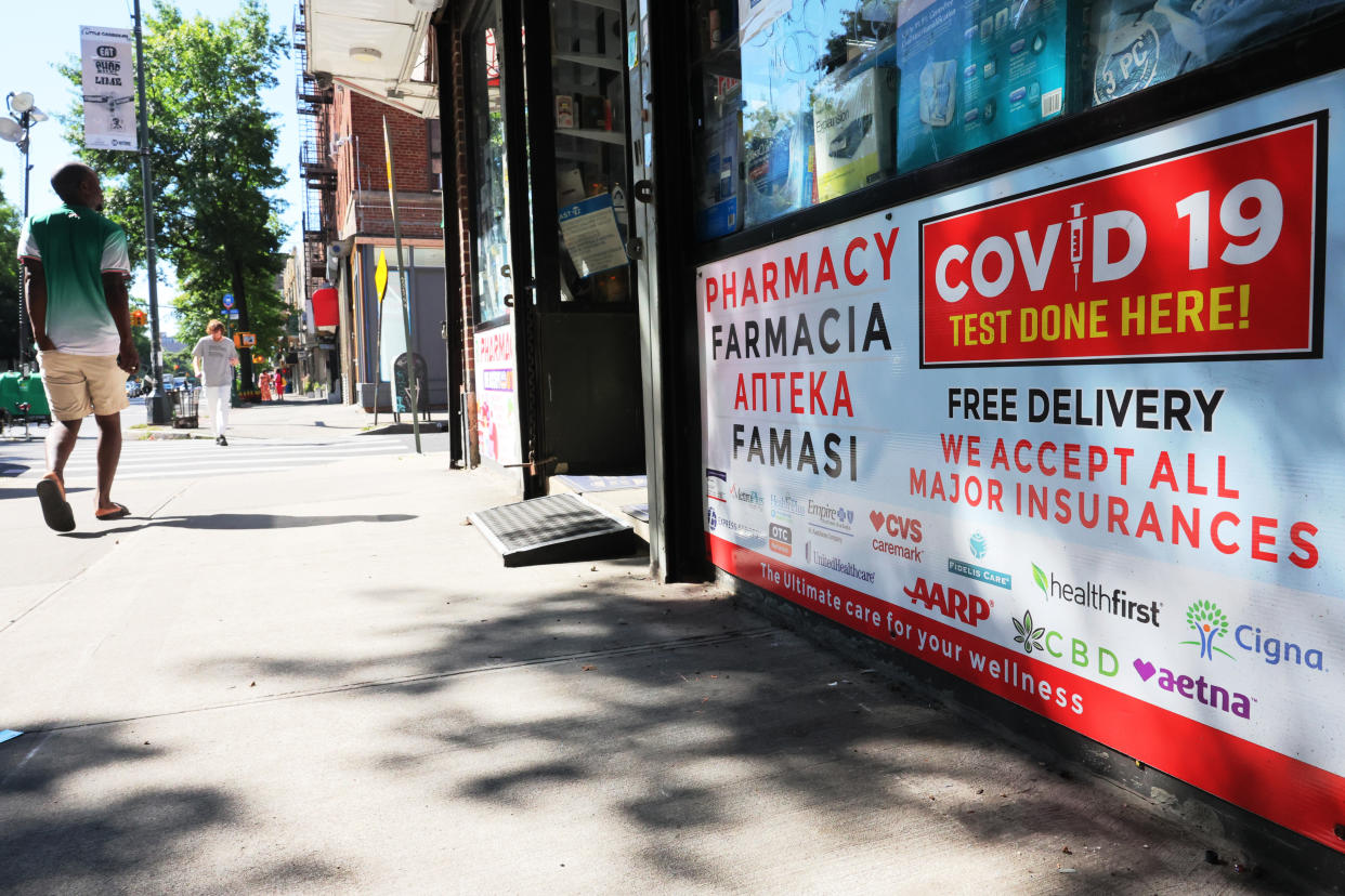 Sign on storefront reading: Pharmacy, COVID-19 test done here! Free delivery. We accept all major insurances. The ultimate care for your wellness.