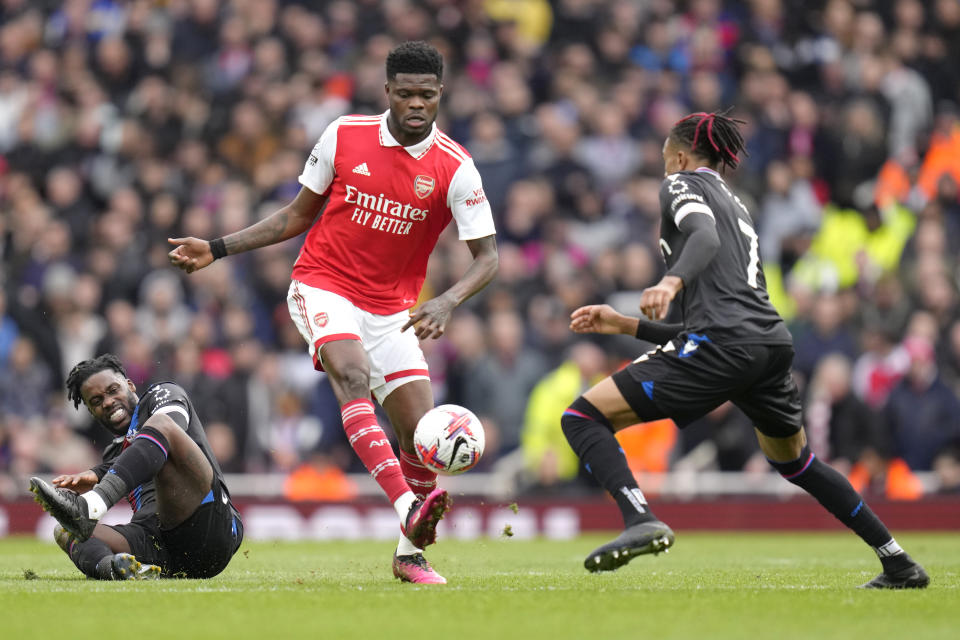 Arsenal's Thomas Partey, centre, challenges for the ball with Crystal Palace's Jeffrey Schlupp, left, and Crystal Palace's Michael Olise during the English Premier League soccer match between Arsenal and Crystal Palace at Emirates stadium in London, Sunday, March 19, 2023. (AP Photo/Kirsty Wigglesworth)