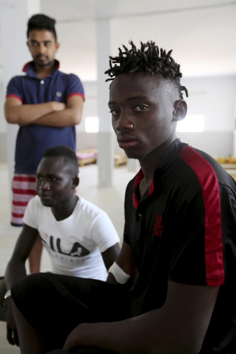 A Malian survivor of a shipwreck sits in the Red Crescent center of Zarzis, southern Tunisia, Thursday, July 4, 2019. The U.N. migration agency says a boat carrying 86 migrants from Libya sank in the Mediterranean overnight, and just three people on board survived, with 82 missing. The shipwreck late Wednesday off the Tunisian city of Zarzis came a day after a deadly airstrike on a Libyan detention center that killed at least 44 migrants.(AP Photo/Sami Jelassi)