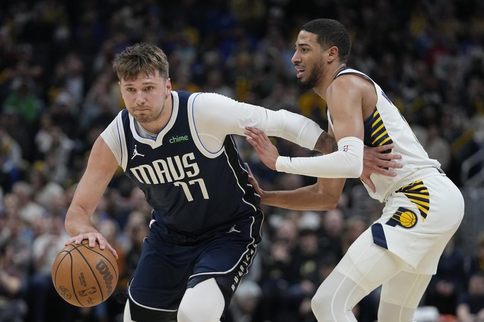 Dallas Mavericks' Luka Doncic (77) heads to the basket against Indiana Pacers' Tyrese Haliburton, right, during the first half of an NBA basketball game, Sunday, Feb. 25, 2024, in Indianapolis. (AP Photo/Darron Cummings)