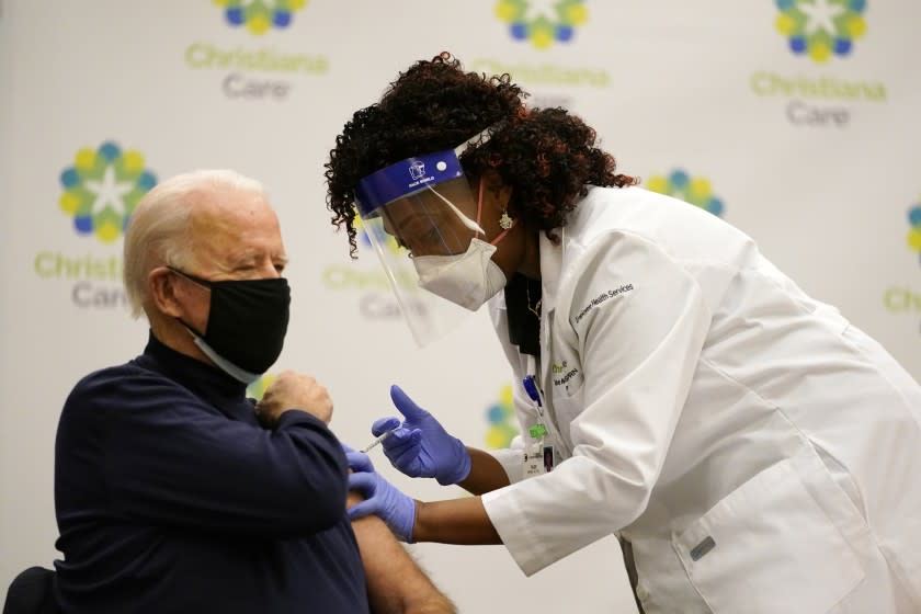 President-elect Joe Biden receives his first dose of the coronavirus vaccine at ChristianaCare Christiana Hospital in Newark, Del., Monday, Dec. 21, 2020, from nurse practitioner Tabe Mase. (AP Photo/Carolyn Kaster)