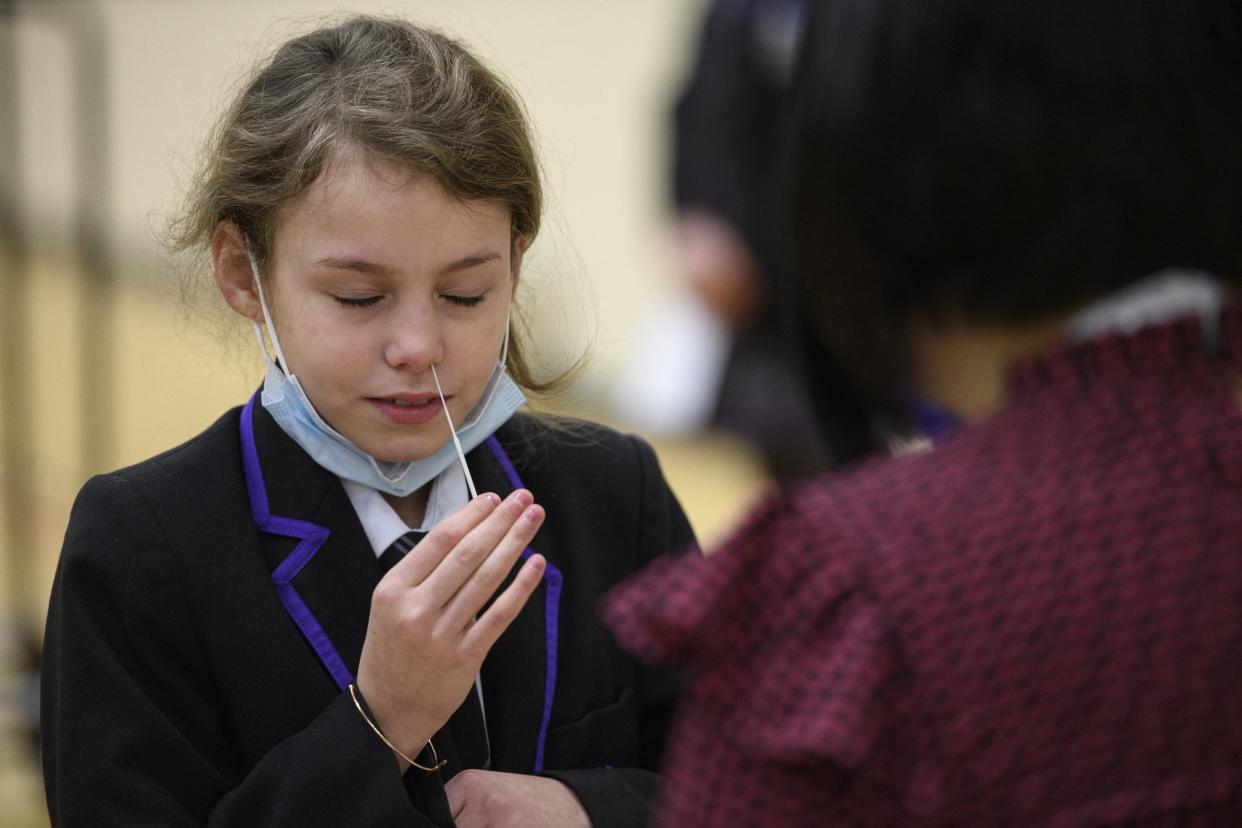 A student at Park Lane Academy takes a Covid-19 lateral flow test in the school Sports Hall which will be processed by a member of staff during a programme to test every pupil in the school on the first day of term, in Halifax, northwest England on January 4, 2022. (Photo by OLI SCARFF / AFP) (Photo by OLI SCARFF/AFP via Getty Images)