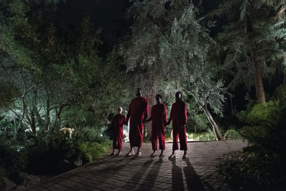 The Wilson family doppelgängers (from left), Pluto (Evan Alex), Abraham (Winston Duke), Umbrae (Shahadi Wright Jospeh) and Red (Lupita Nyong’o) make their presence known in "Us," written, produced and directed by Jordan Peele.