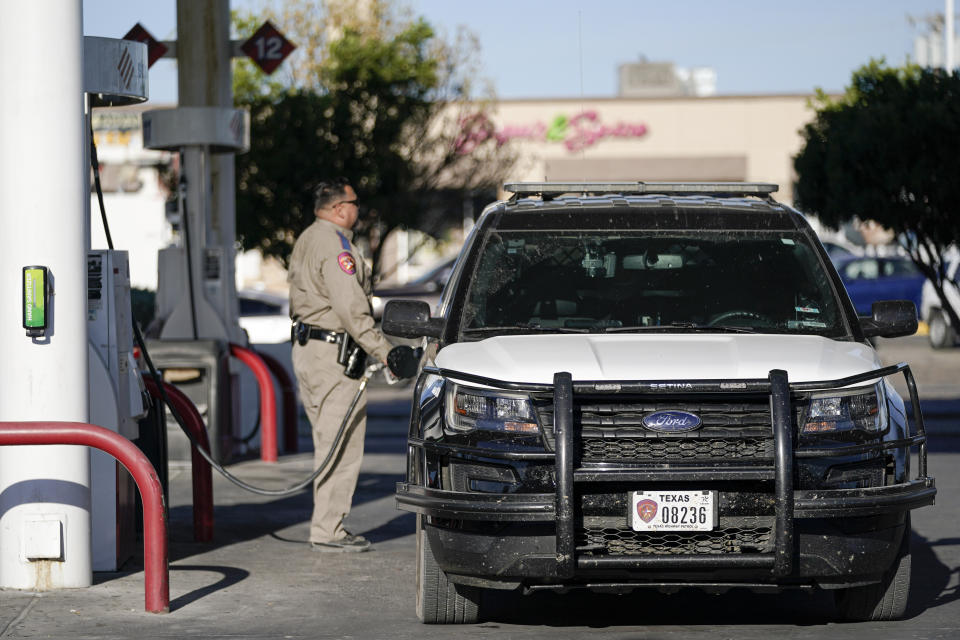 An officer fills up a Department of Public Safety vehicle at a gas station, Wednesday, Sept. 22, 2021, in Del Rio, Texas. Federal officials announced the border crossing between Del Rio, Texas, and Ciudad Acuña, Mexico. would reopen to passenger traffic late Saturday afternoon and to cargo traffic on Monday. On Friday, the camp on the U.S. side that once held as many as 15,000 mostly Haitian refugees was completely cleared. (AP Photo/Julio Cortez)