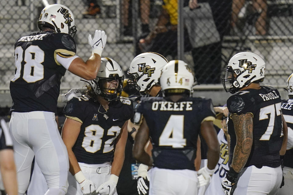 Central Florida tight end Alec Holler (82) celebrates his 23-yard touchdown reception with teammates, including tight end Jake Hescock (88), wide receiver Ryan O'Keefe (4) and offensive lineman Lokahi Pauole (77), during the first half of an NCAA college football game against Boise State on Thursday, Sept. 2, 2021, in Orlando, Fla. (AP Photo/John Raoux)