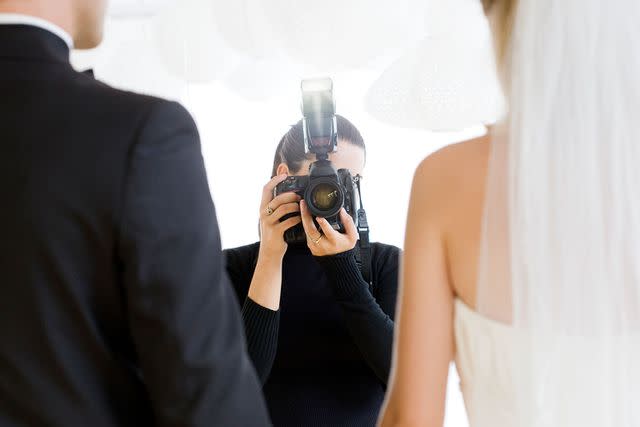 <p>getty</p> Stock image of a photographer trying to photograph a wedding couple