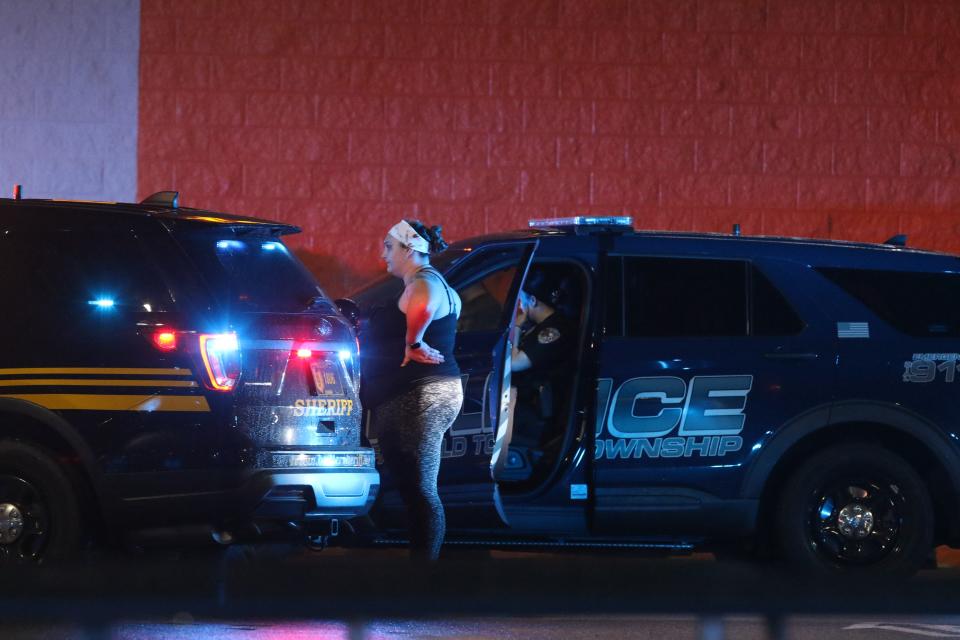 A pedestrian looks on as emergency personnel respond to a shooting at the Walmart Supercenter in Fairfield Township on Thursday May 26, 2022. 