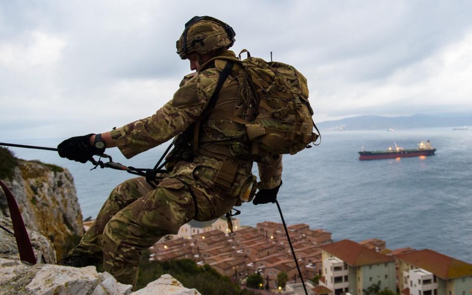 A Royal Marine prepares to abseil down a rock cliff as part of vertical assault drills during Exercise Serpent Rock in Gibraltar - Anthony Upton