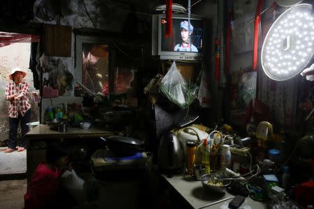 Migrant worker Wang Qin stands outside in one-room home at the outskirts of Beijing, China October 1, 2017. REUTERS/Thomas Peter