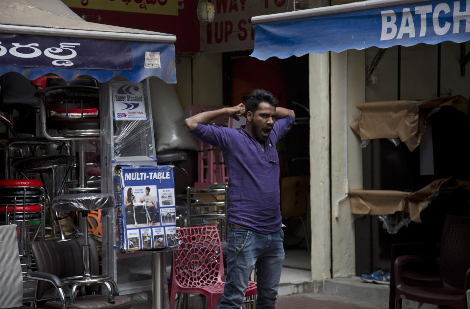 In this Dec. 17, 2018, photo, a salesman yawns while waiting for customers at the Nampally furniture market in Hyderabad, India. This furniture market, where customers haggle over prices and work with carpenters to design made-to-order housewares, is the kind of competition Swedish giant Ikea faces in tackling the $40 billion Indian market for home furnishings, which is growing quickly along with the country’s consumer class. (AP Photo/Mahesh Kumar A.)