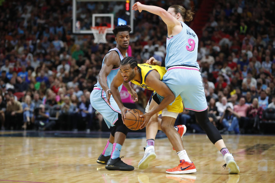 Indiana Pacers forward T.J. Warren, center, works between Miami Heat forward Jimmy Butler, left, and forward Kelly Olynyk during the first half of an NBA basketball game Friday, Dec. 27, 2019, in Miami. (AP Photo/Wilfredo Lee)