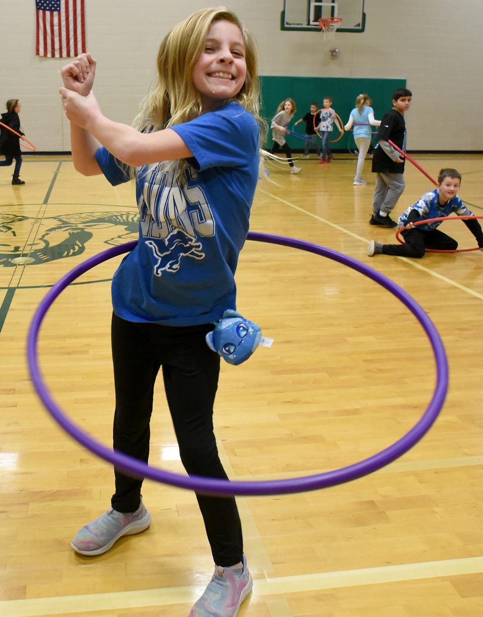 Barnes Elementary third grader Ellie Johnson, 8, twist and turns the hula hoop in gym class Thursday during Detroit Lions Day.