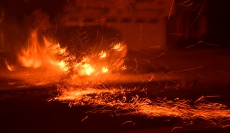 Flying embers fill the night sky to the ground from a wind-driven wild fire called the Saddle Ridge fire in the early morning hours Friday in Porter Ranch