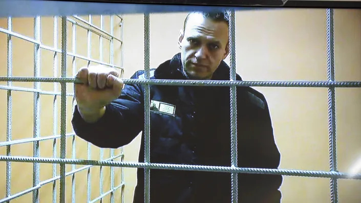 Alexei Navalny stands in a prison cell. 