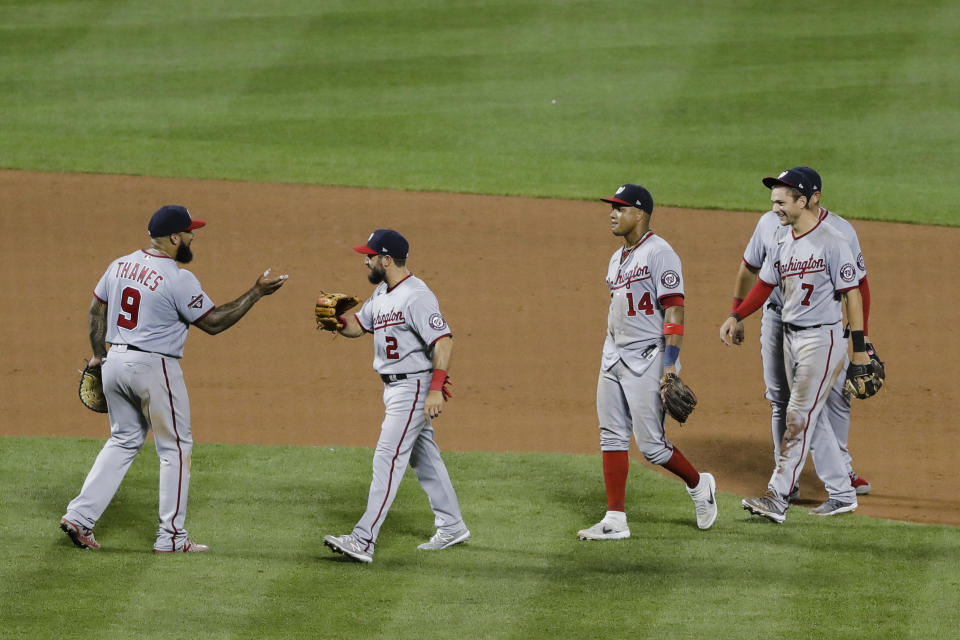 Washington Nationals' Eric Thames (9) and Adam Eaton (2) celebrate with teammates Starlin Castro (14) and Trea Turner (7) after a baseball game against the New York Mets Tuesday, Aug. 11, 2020, in New York. The Nationals won 2-1. (AP Photo/Frank Franklin II)