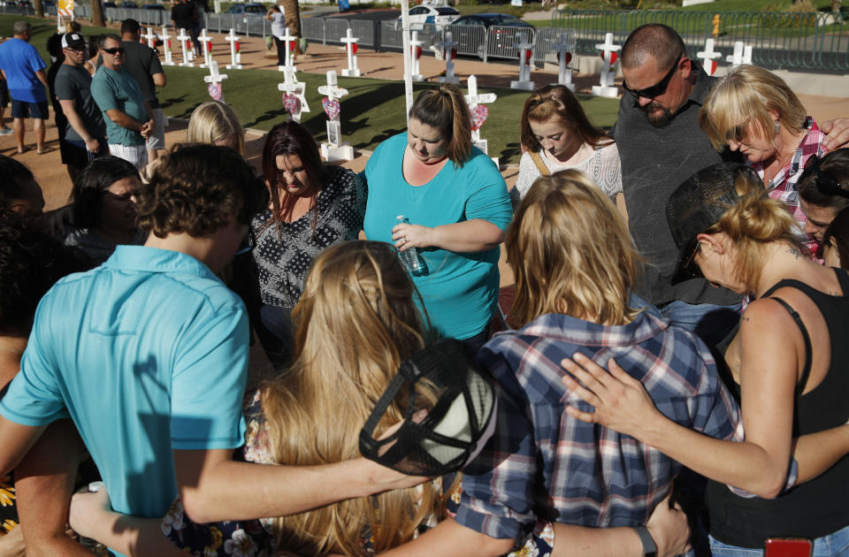 People pray at a makeshift memorial for victims of the Oct. 1 2017, mass shooting in Las Vegas, Sunday, Sept. 30, 2018, in Las Vegas. (AP Photo/John Locher)