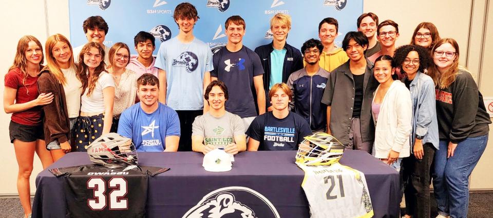Bartlesville High's Duke McGill, seated center, is joined by some of his best friends when he inks a letter of intent to accept a lacrosse athletic scholarship from St. Leo (Fla.). Also seated are Ridge Brewington, left, and Mason Manley. On the second row, from left, are Katy Shoesmith, Stella Stroope, Emma Sanderson, Liam Wisner, Camille Barnett, Eli Blankenship, Nick Smith, Carter Manley, Charlie Olson, Tarun Vinodkumar, Ethan Kallweit, Adam Lodrigueza, Jackson Manor, Lukas Copeland, Maria Covarrubias, Savannah Wooten, Logan Cates and Jordan Dumonceaux.
