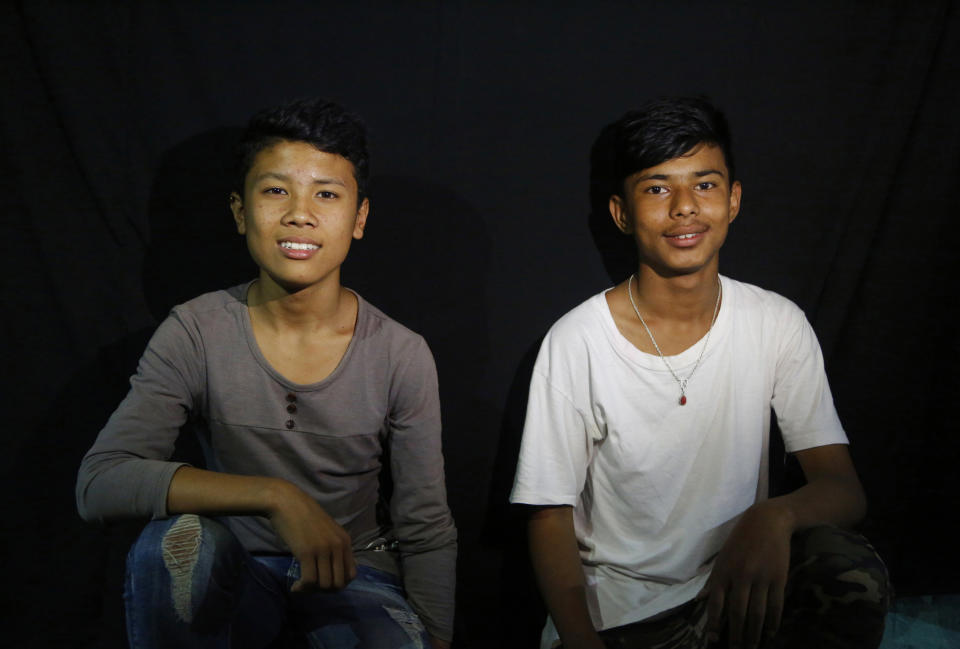 In this Sept. 26, 2018, photo, students Ukesk Chikanbanjar, right, and Rohit Rajchal pose for photographs without the mask of god Bhot Bhairabh in Kathmandu, Nepal. For centuries, Nepal has celebrated the Indra Jatra festival of masked dancers, which officially begins the month-long festivities in the Hindu-dominated Himalyan nation. The dancers, who come from a variety of backgrounds, pull off this performance every year despite minimal financial support from the government and other sources, they say. (AP Photo/Niranjan Shrestha)