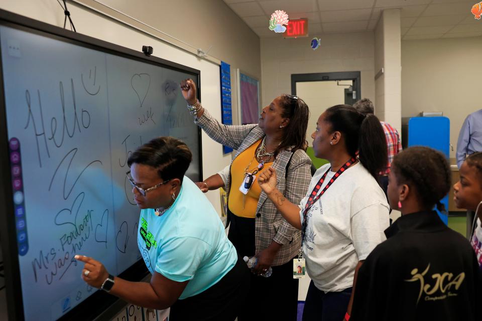 Duval school system educators explore a smart-touch screen white board in this August photo from the opening of Rutledge H. Pearson Elementary School. Work on the school, the first school completed with half-penny sales tax funds, finished about 40 percent over budget, while others under construction face bigger overruns.