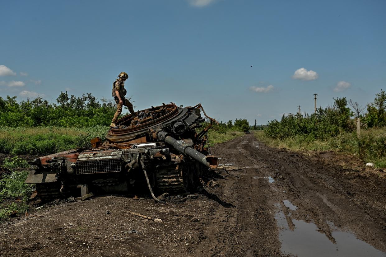 Ukrainian serviceman inspects a destroyed Russian tank is seen in the recently liberated village of Novodarivka (REUTERS)