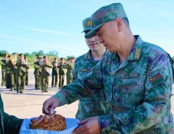  在軍樂隊演奏聲中，白俄羅斯和中國指揮官還依照傳統掰麵包。 圖 : 翻攝自解放軍報 