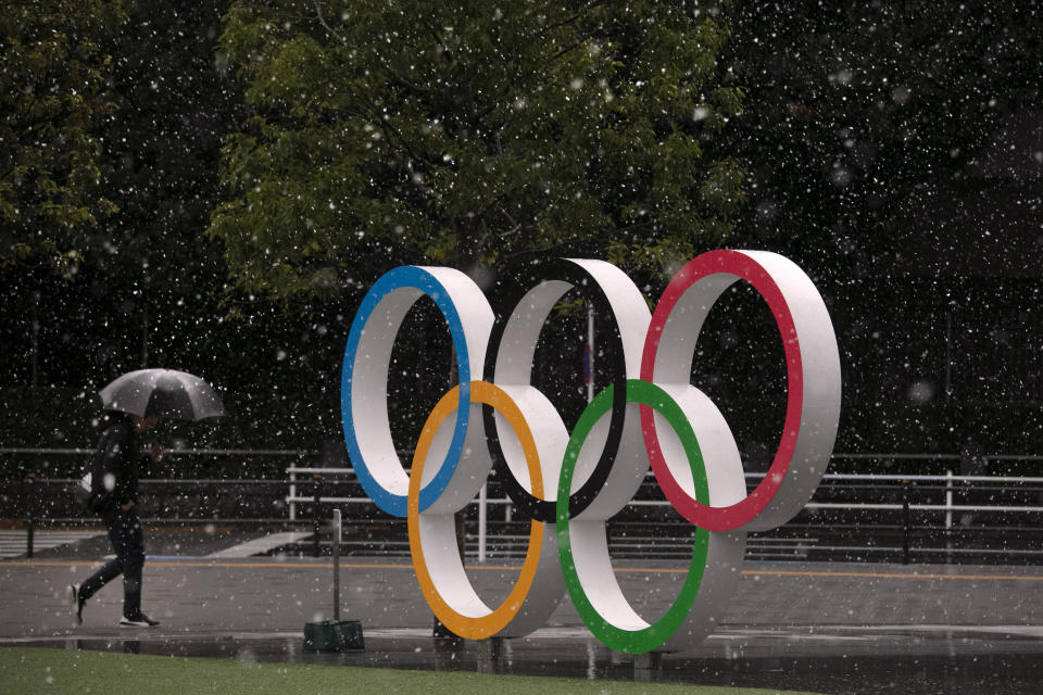 Snow falls on the Olympic rings near the New National Stadium in Tokyo, Saturday, March 14, 2020. (AP Photo/Jae C. Hong)