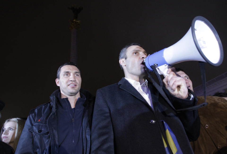 FILE - In this Friday, Nov. 22, 2013 file photo, world heavyweight boxing champion Wladimir Klitschko of Ukraine, left, and lawmaker and chairman of Ukrainian opposition party Udar (Punch), WBC heavyweight boxing champion Vitali Klitschko attend a night rally in support of Ukraine's integration with the European Union in the center of Kyiv, Ukraine. Former heavyweight boxing champion turned philanthropist and management thinker Wladimir Klitschko praises his home country of Ukraine in a year when it has had a starring role in politics and on television in the United States. (AP Photo/Sergei Chuzavkov, file)