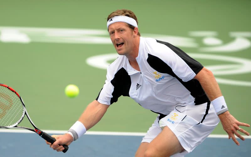 FILE PHOTO: Jonas Bjorkman of Sweden returns the ball to Lleyton Hewitt of Australia during their men's first round tennis match at the Beijing 2008 Olympic Games