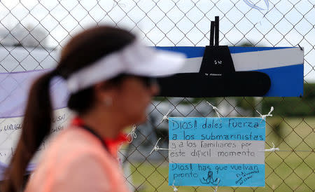 A woman walks past a banner in the colours of the Argentine national flag in support of the 44 crew members of the missing at sea ARA San Juan submarine, placed on a fence at an Argentine naval base in Mar del Plata, Argentina November 22, 2017. Words on the flag read "We are with you". REUTERS/Marcos Brindicci