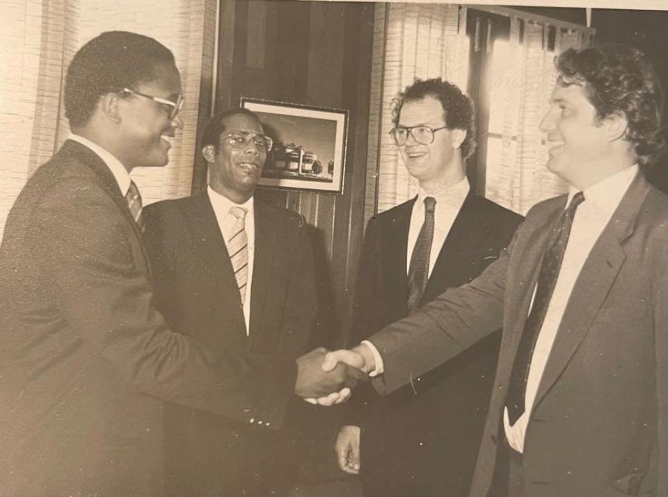 Guthrie (in Trinidad & Tobago, 1980s) shaking hands with the Dean of the University of West Indies; looking on are Mr Justice Austin Davis, second leftm and Guthrie’s friend Edward Fitzgerald 