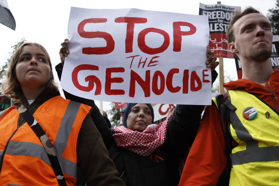 Demonstrators hold up flags and placards during a pro Palestinian demonstration in London, Saturday, Oct. 21, 2023. (AP Photo/David Cliff)