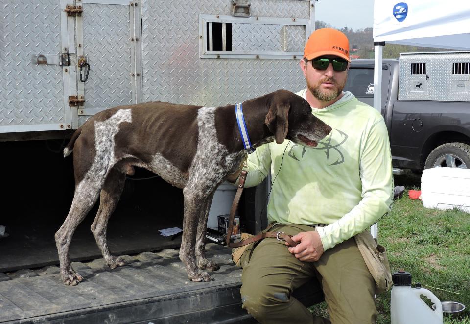 Brandon Tarquinio of Coal Center, Washington County, pets Razz, a two-time national field trialing champion, at the Bill Roff  Memorial Chukar Championship in Fayette County. Tarquinio and his wife, Lauren, travel to field trials across the United States.